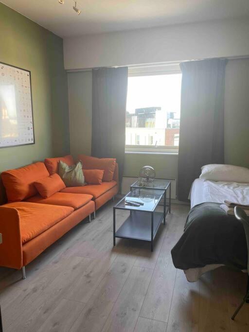 a living room with an orange couch and a bed at G23 in Sarpsborg