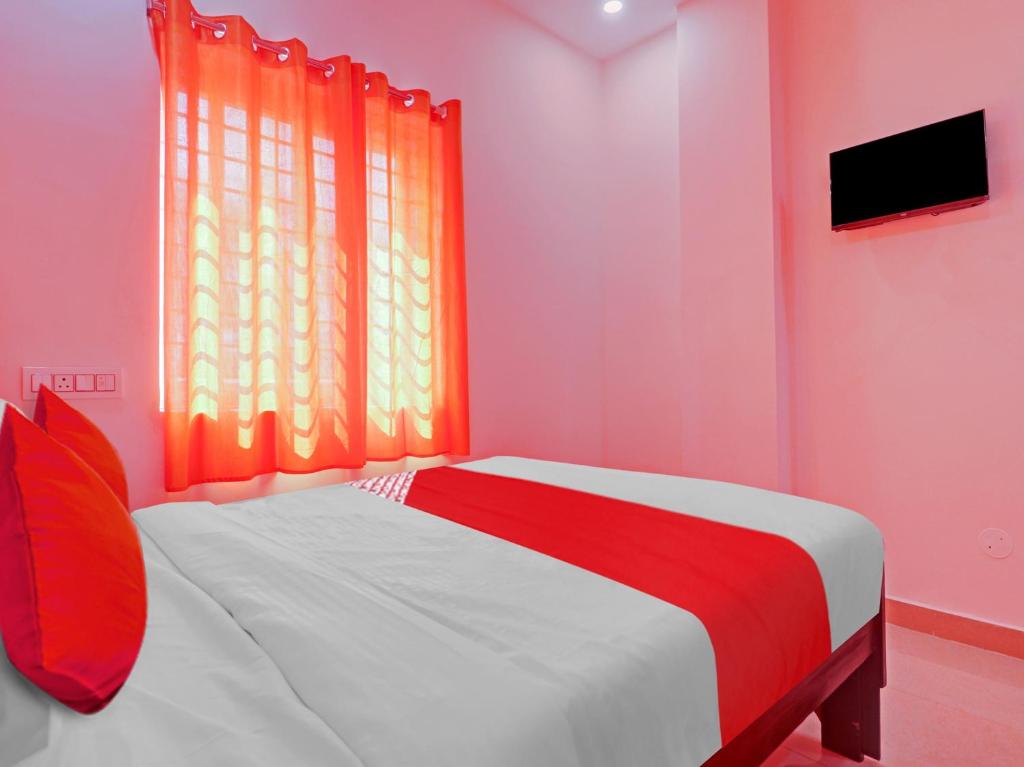 OYO Hotel Shannu Grand في حيدر أباد: غرفة نوم وردية مع سرير أمام النافذة