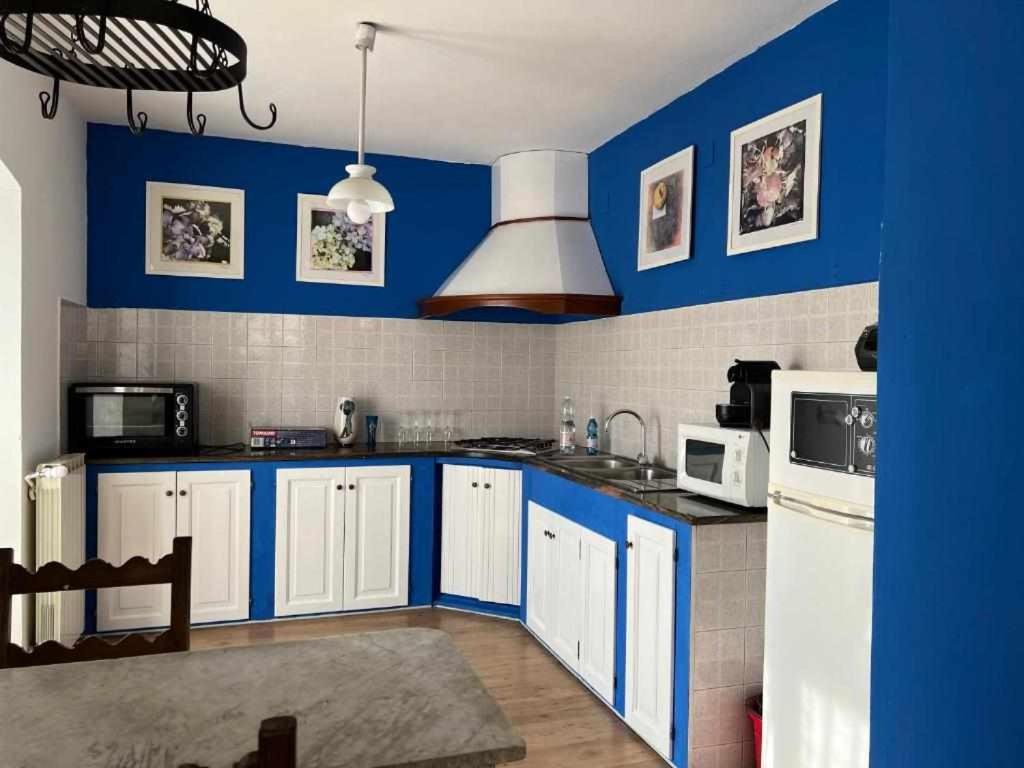 a kitchen with blue walls and white cabinets at 4 tea 4 house in Romano Canavese