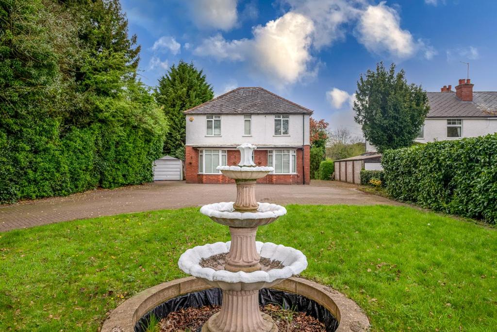 a fountain in a yard in front of a house at Spacious Worcester City Centre House in Worcester