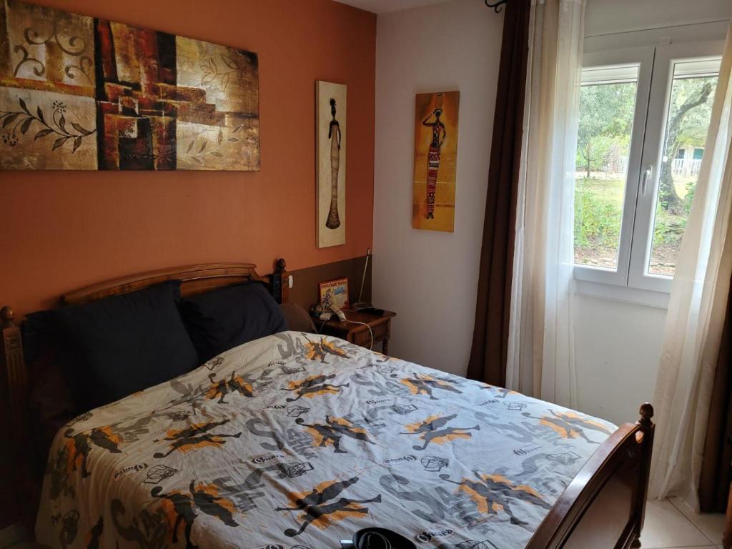 ein Schlafzimmer mit einem Bett mit einer Bettdecke und Vögeln darauf in der Unterkunft chambre double in Taulignan