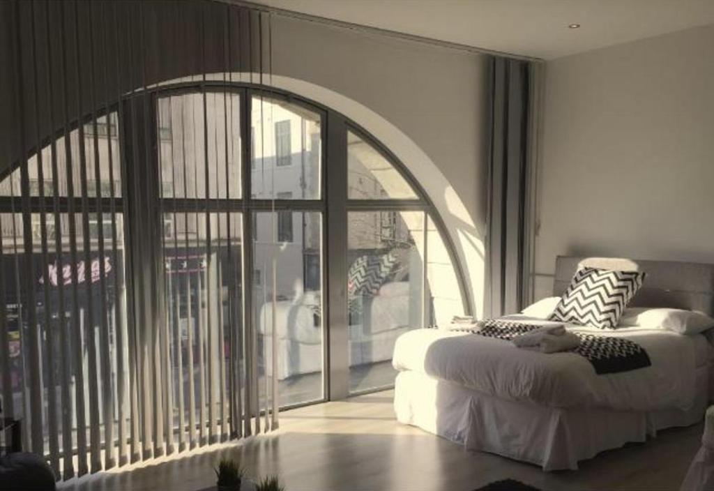 a bedroom with a bed and a large window at Captivating 1-Bed Apartment in Swansea in Swansea