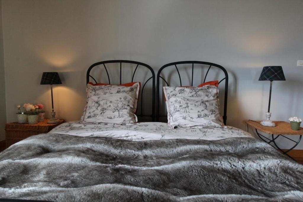 1 dormitorio con 1 cama con manta y almohadas en Jallanges, en Fontevraud-l'Abbaye