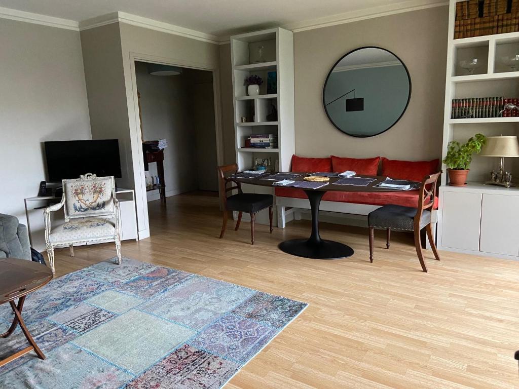 - un salon avec une table et un miroir dans l'établissement Confortable 3 pièces 75m2, Vincennes Centre, à Vincennes