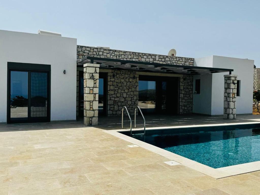 a house with a swimming pool next to a building at Villa Elaia in Sitia