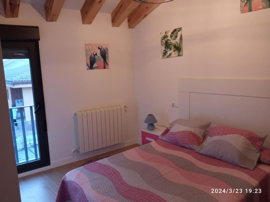 a bedroom with a bed and a window at Casa Rural - De Brevas a Higos in Espirdo