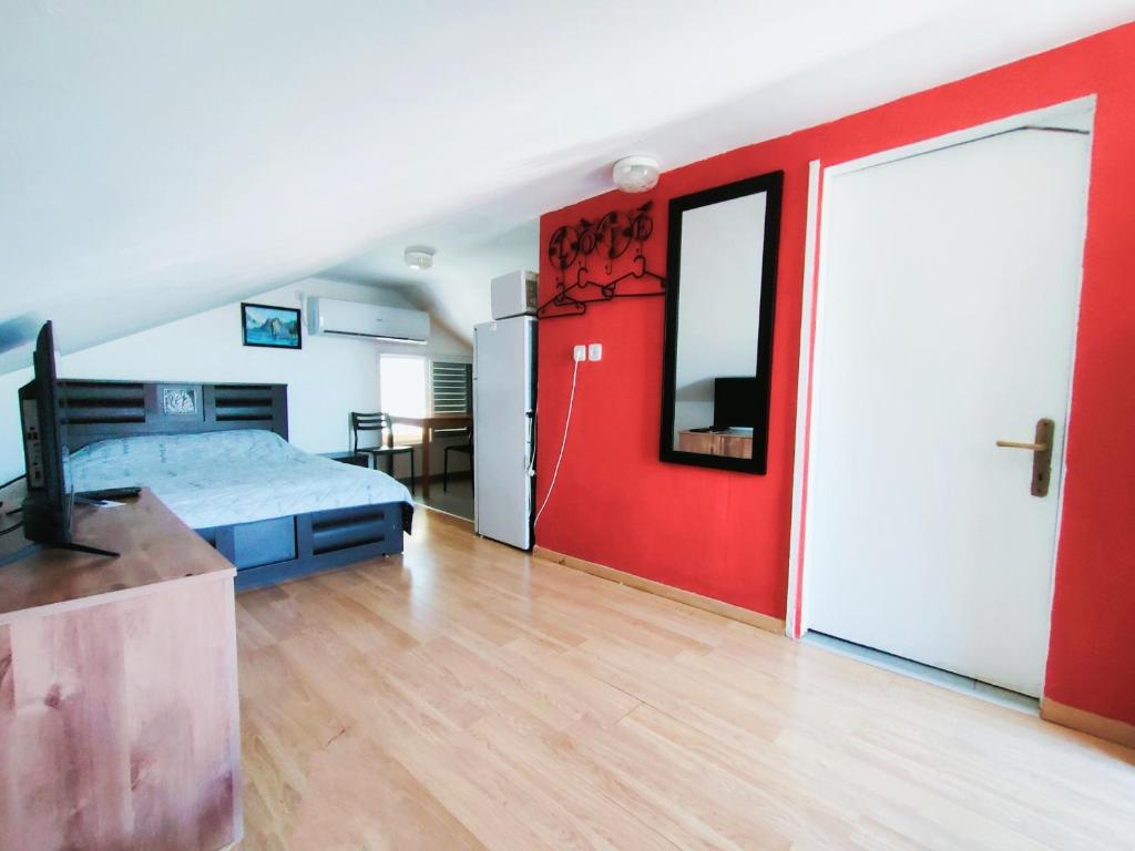 Guest House VeryMary Eilat Stydio في إيلات: غرفة نوم بسرير وجدار احمر
