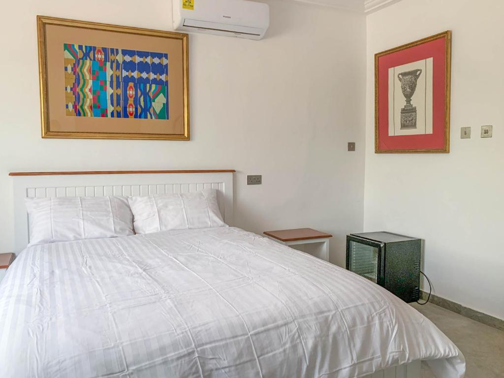 a bedroom with a bed and a picture on the wall at Conys Guest House in Kwabenyan