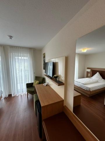 Habitación de hotel con 1 dormitorio con cama y escritorio en Gästehaus GN8, en Rielasingen-Worblingen