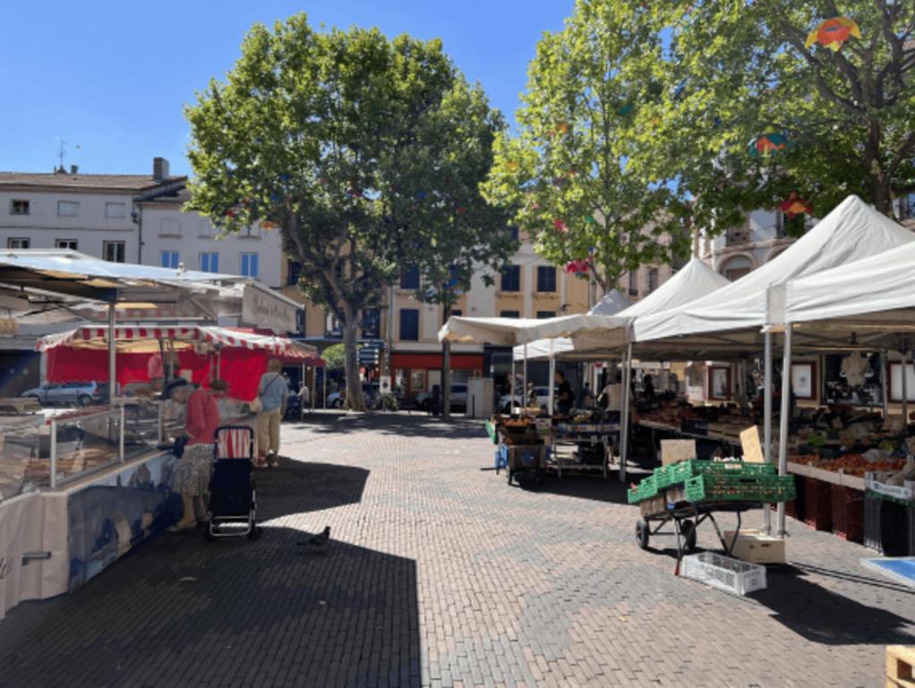 a market with white umbrellas and stalls on a street at APPARTEMENT HYPER CENTRE numéro 101 in Roanne