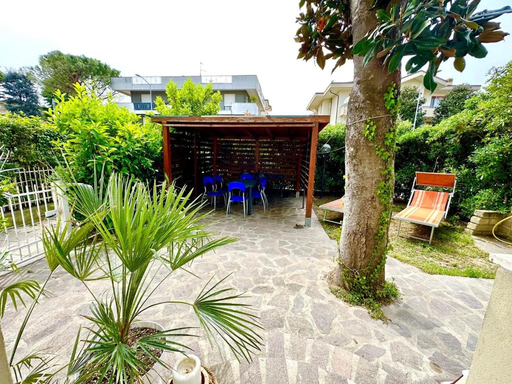 un patio con tavolo, sedie e un albero di Giardino al mare a Rimini