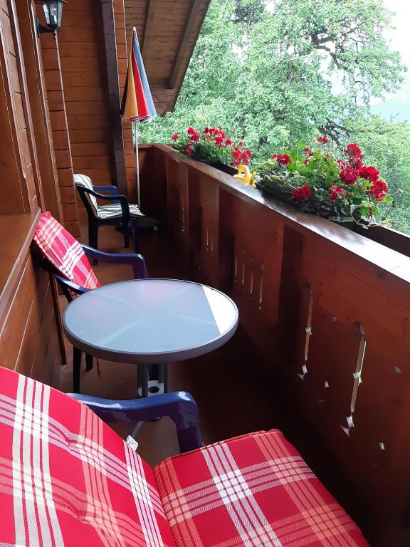 a table and chairs on a porch with a window at Landhaus Berthold in Bürserberg