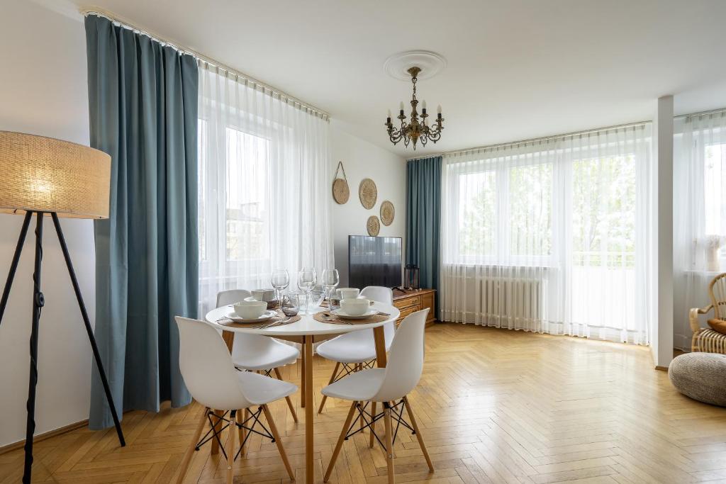 a dining room with a table and white chairs at 20 Apart - Mieszkanie dla 4 osób in Gdynia