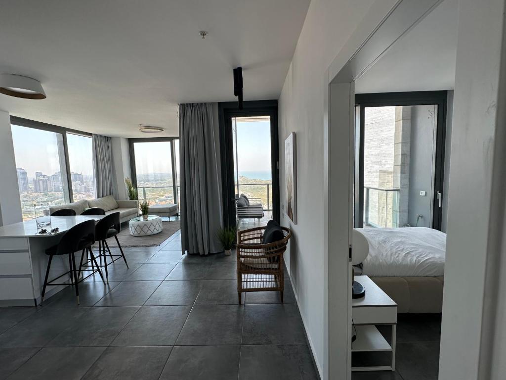 een slaapkamer met een bed en een tafel en stoelen bij דירת פאר על הים VIP apartment near the beach in H̱adera
