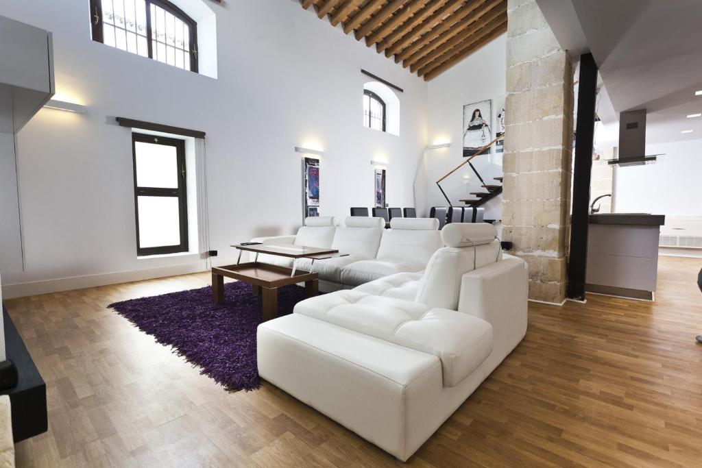 sala de estar con muebles blancos y alfombra morada en Dúplex tipo Loft con piscina, en Jerez de la Frontera
