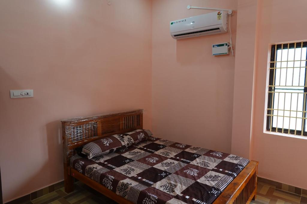 a bedroom with a bed and a air conditioner at Wisma Gokilambal Residency in Tiruvannāmalai