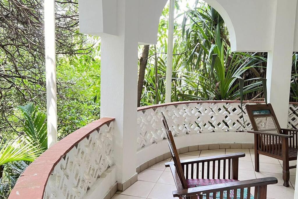 un porche con 2 sillas y un banco en Mombasa at your doorstep!, en Mombasa