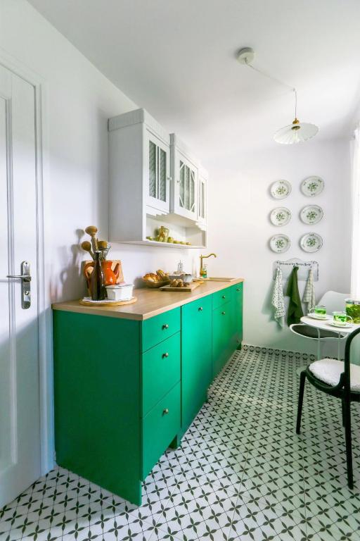 a kitchen with green cabinets and a table in a room at Kłodnia 1 in Rytel