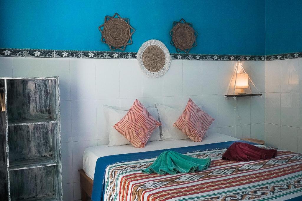 a bedroom with a bed with colorful pillows on it at Pandan Wangi in Nusa Lembongan