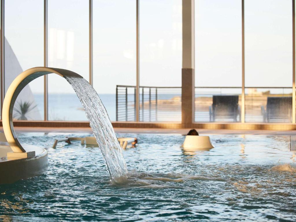 una fontana in una piscina in un edificio di Sofitel Quiberon Thalassa sea & spa a Quiberon