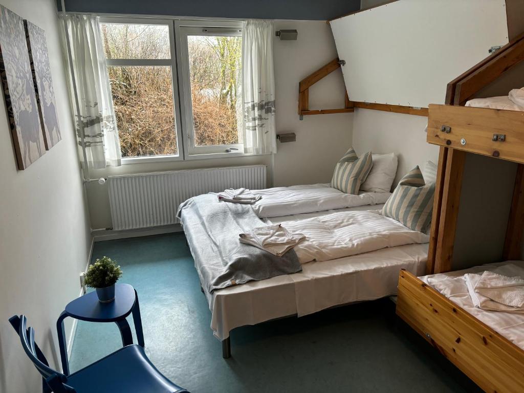 Habitación pequeña con 2 camas y ventana en Danhostel Aalborg, en Aalborg