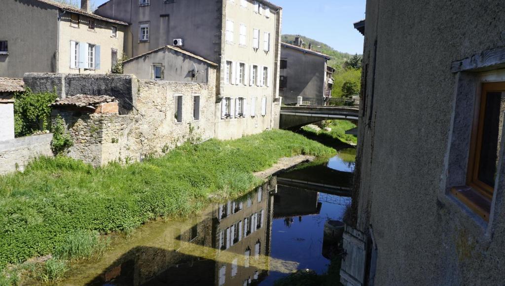 vistas a un río con edificios y un puente en River House in medieval bastide South of France, en Chalabre