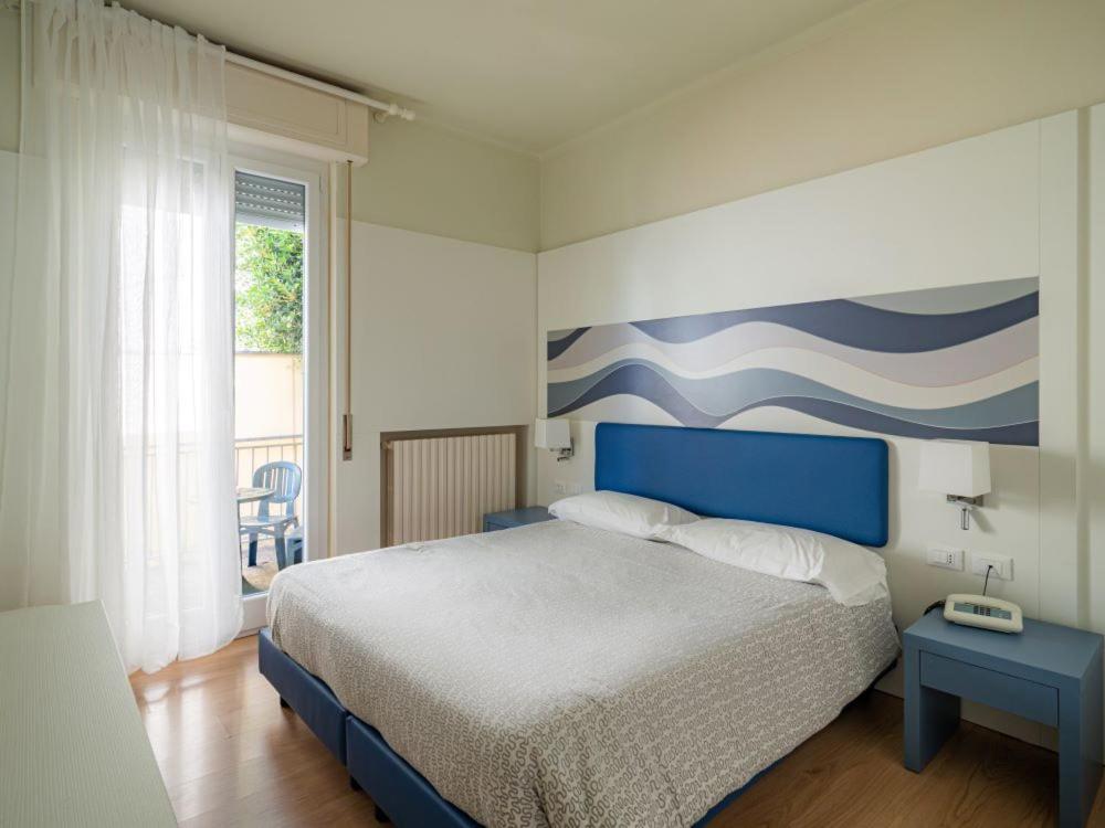 1 dormitorio con 1 cama y una pintura en la pared en Hotel Il Nido, en Tellaro