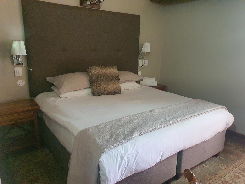ein Schlafzimmer mit einem großen Bett mit großem Kopfteil in der Unterkunft Fairview Hotels,Spa & Golf Resort in Tzaneen