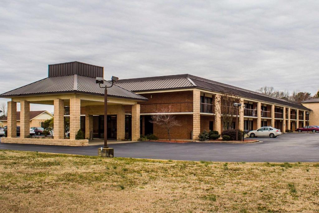 a large building with a car parked in a parking lot at Quality Inn Kinston Hwy 70 in Kinston