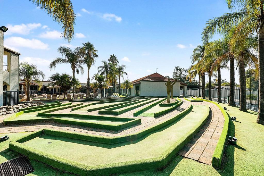 a park with green steps and palm trees at Quality Resort Siesta in Albury