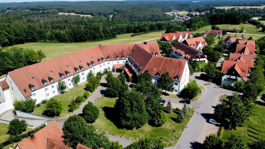 eine Luftansicht eines großen Gebäudes mit roten Dächern in der Unterkunft Hotel Gut Matheshof, BW Signature Collection in Rieden