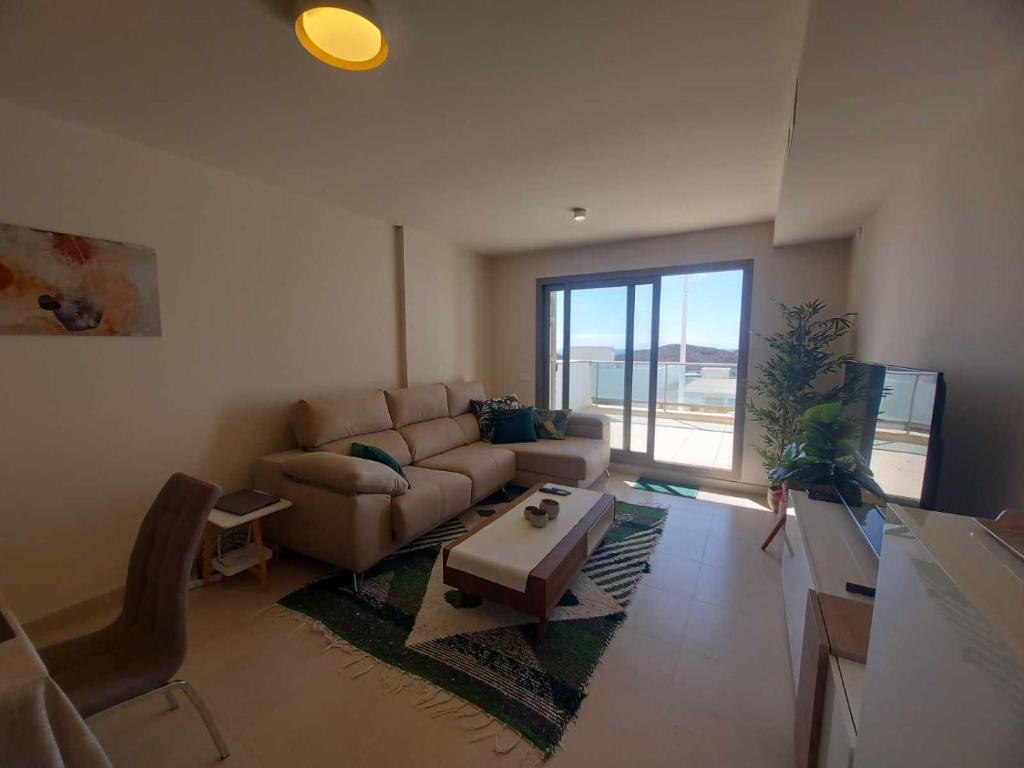 sala de estar con sofá y mesa en La Perla Verde apartment on Aguilón GolfPulpí, en Pilar de Jaravía