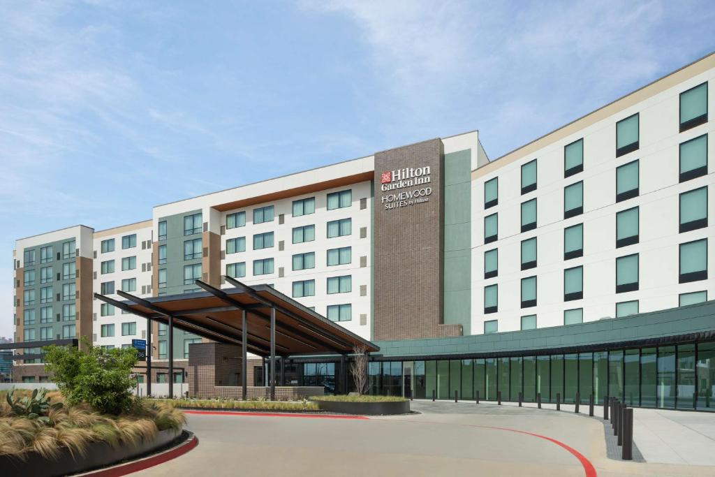 a large white building with a sign on it at Hilton Garden Inn Grand Prairie At EpicCentral in Grand Prairie