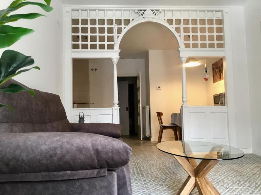 Una sala de estar con un sofá y una mesa de cristal. en Rincón en edificio Modernista en centro de Soria, en Soria