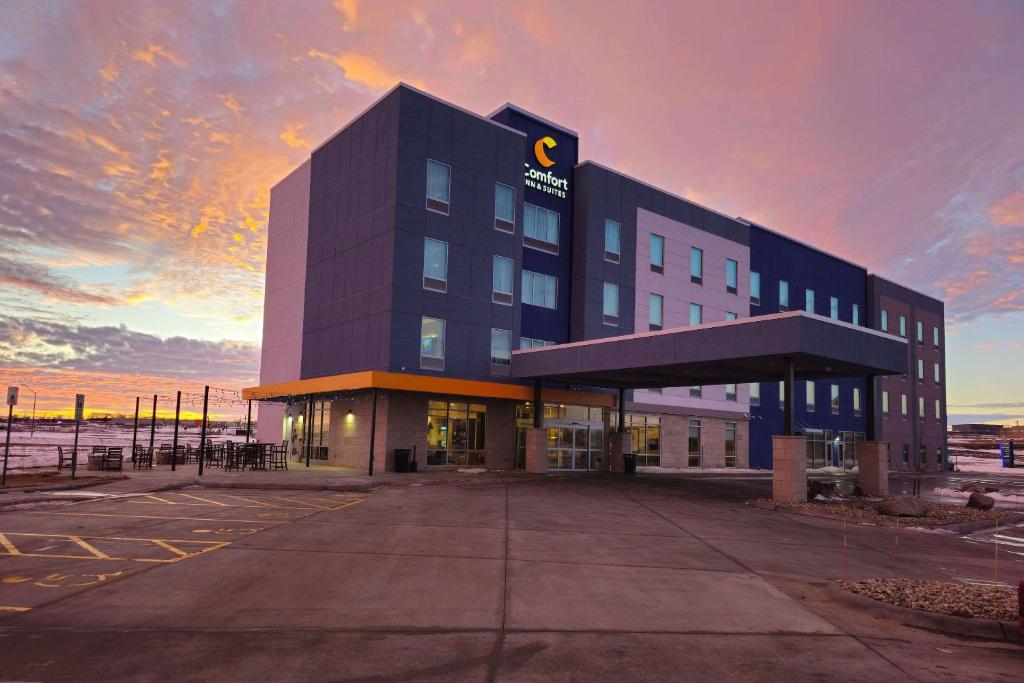 a large black building with a sunset in the background at Comfort Inn & Suites at Sanford Sports Complex in Sioux Falls