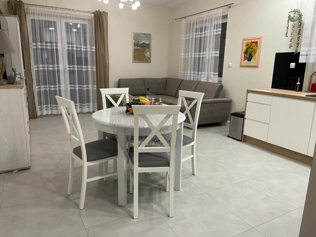 kuchnia i salon ze stołem i krzesłami w obiekcie Apartament na Miłej w mieście Kostrzyn nad Odrą