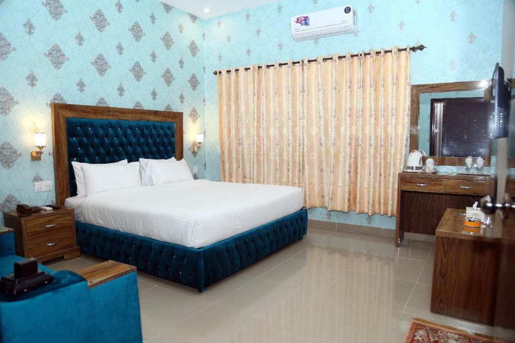 een slaapkamer met een bed en een wastafel bij Hotel Grand Pearl in Lahore