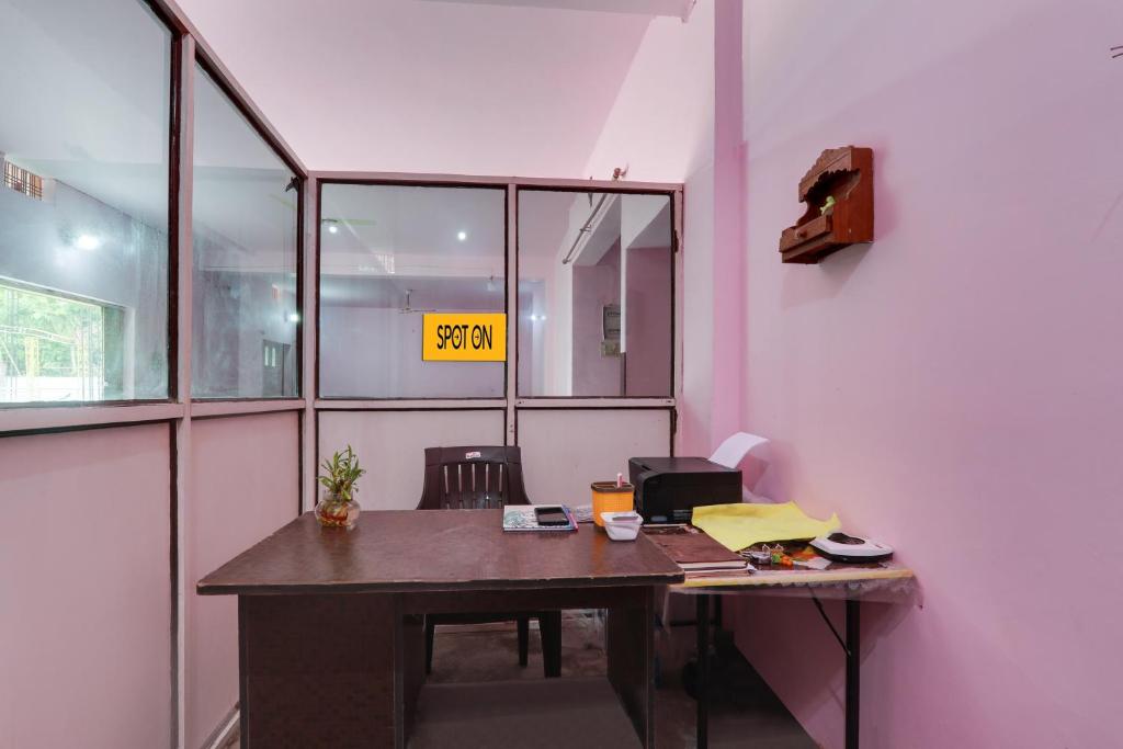 an office with a desk with a sign on the wall at SPOT ON New Modern Guest House in Varanasi