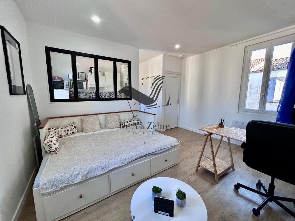 une chambre avec un grand lit et un bureau dans l'établissement Le Moderne - Appartement situé en plein centre-ville, à Rochefort