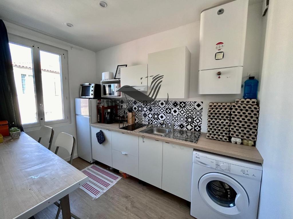 eine Küche mit Waschmaschine in der Unterkunft Appartement moderne - Rochefort in Rochefort