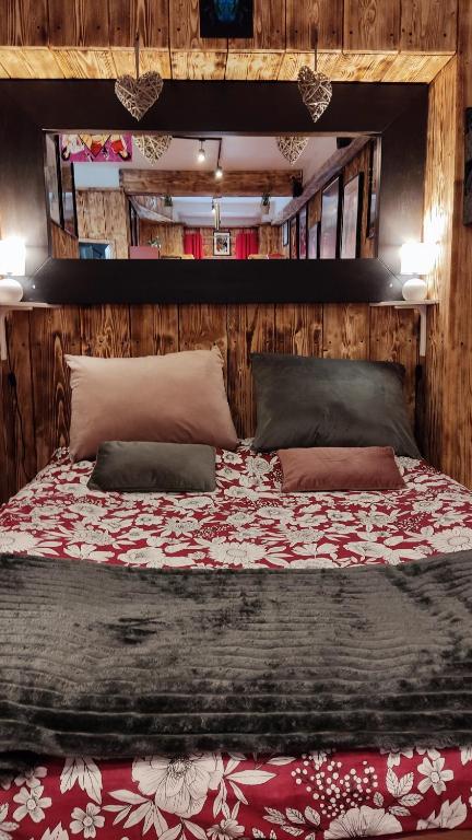 ein großes Bett in einem Zimmer mit Holzwänden in der Unterkunft Romantic Room - Superbe Appartement Studio Jardin - Proche Disneyland Paris in Crécy-la-Chapelle
