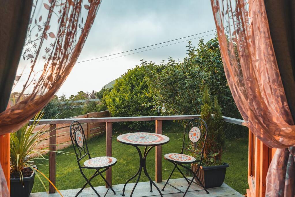 un patio con 2 sillas y una mesa en el balcón en Sea View Pod Close to Mountains / Snowdonia en Caernarfon