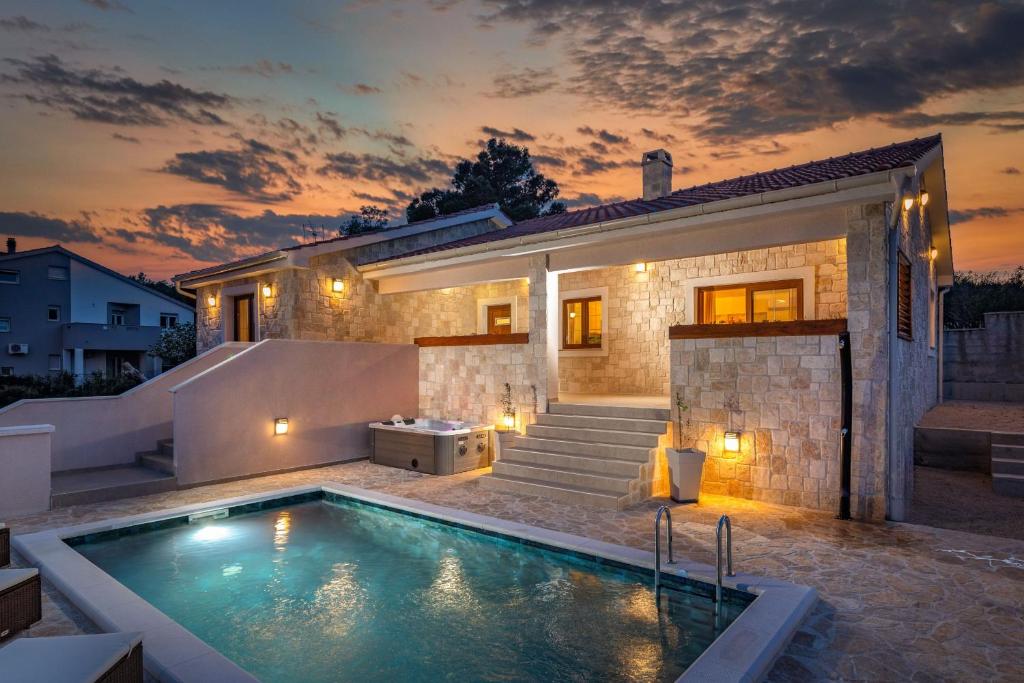 uma villa com piscina em frente a uma casa em Villa Alora em Pridraga