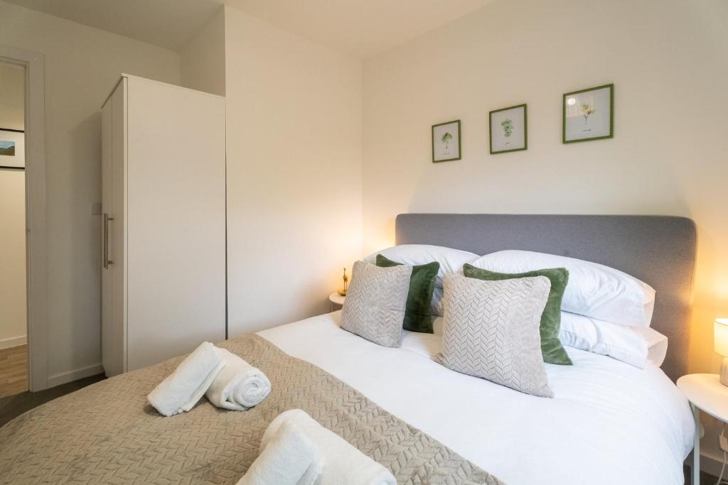 ein Schlafzimmer mit einem großen Bett mit weißen Kissen in der Unterkunft Comfy One BR | Free Parking in Taunton