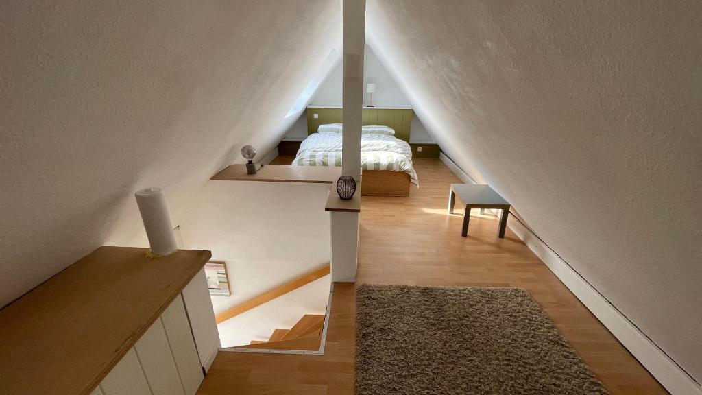 a attic room with a bed and a staircase at Apartment über 2 Etagen nahe Messe und Stadion in Dortmund