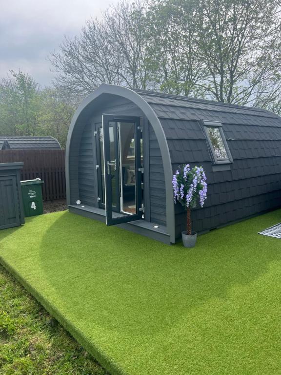 a large circular shed with an open door on a lawn at Little Bunny Retreat in Bradmore