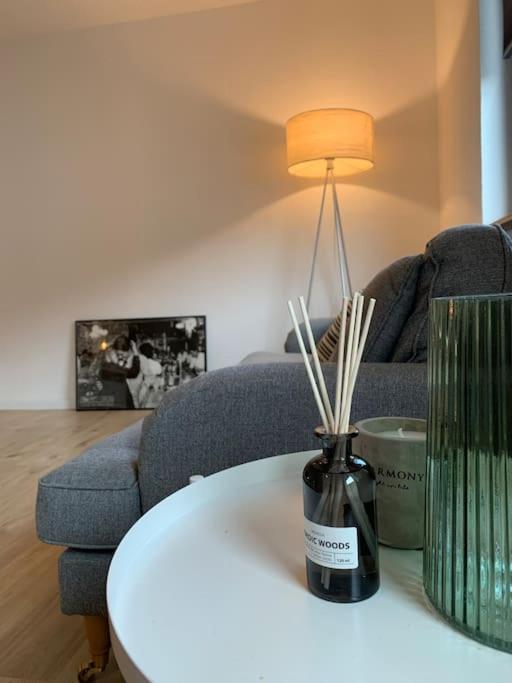 een vaas op een tafel met een lamp en een bank bij Stilvolle Wohnung mit Balkon & Parkplätzen in Bremen