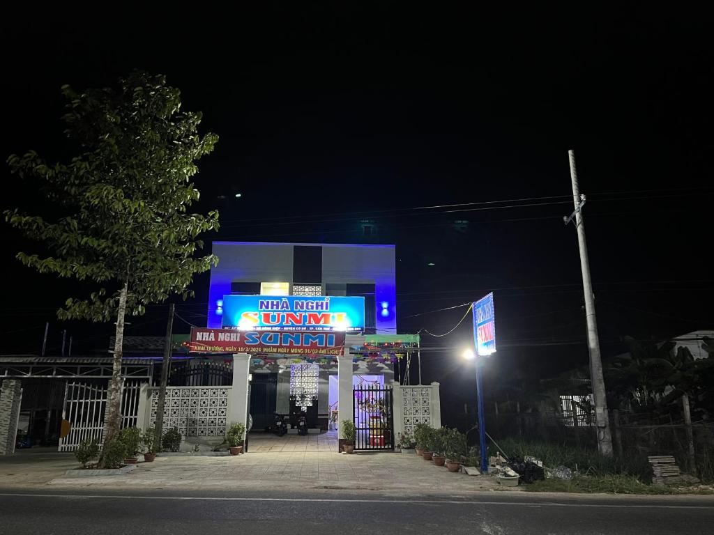 une station-service avec un panneau de néon la nuit dans l'établissement Nhà nghỉ Sunmi, à Cần Thơ