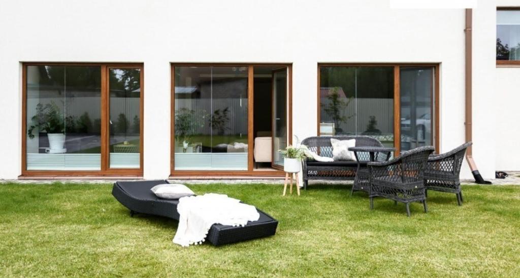a patio with a couch and chairs on the grass at Kanali Villa in Pärnu