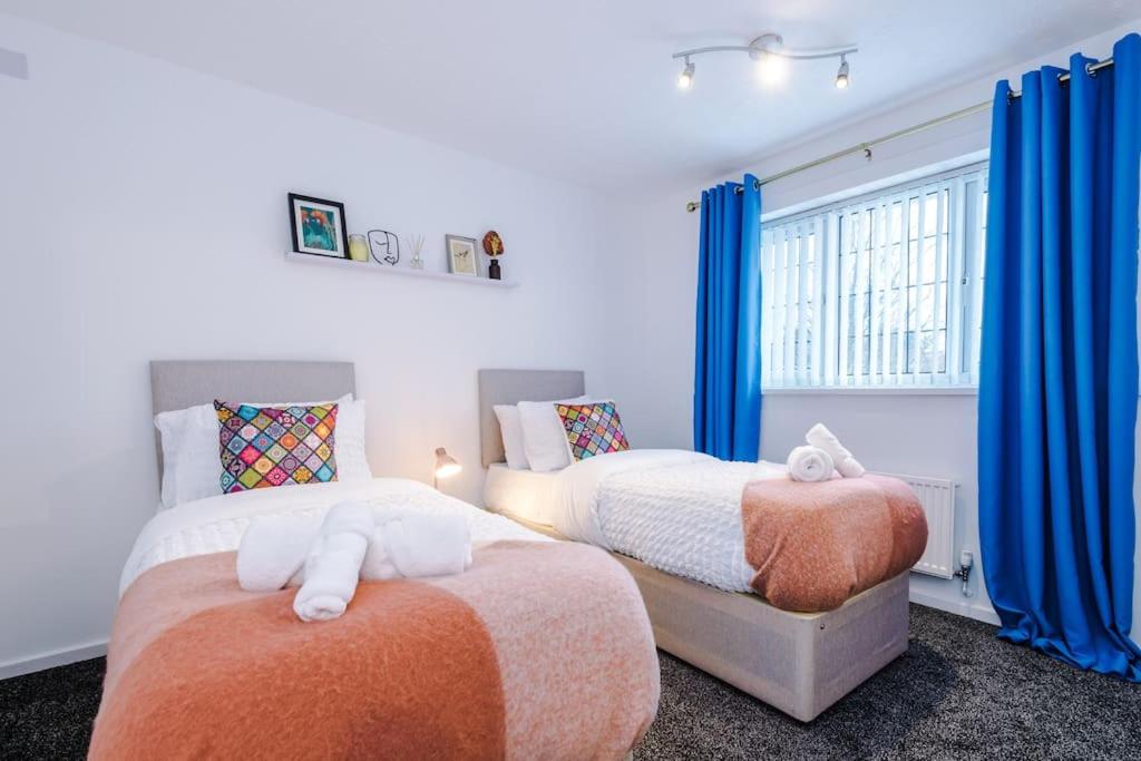 2 camas en un dormitorio con cortinas azules en 3 Bed+2 Bath Perfect Contractors & Groups en Ocker Hill